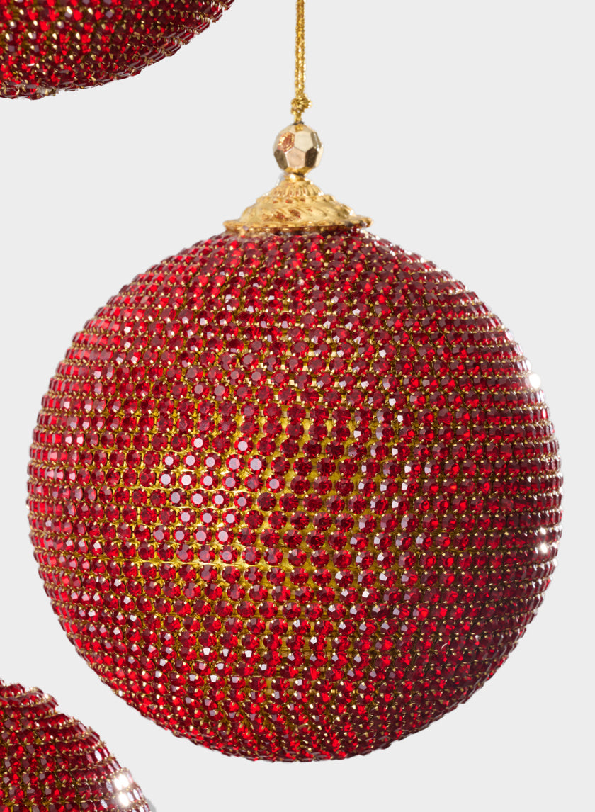 A close-up of the 4in Round Red Full Rhinestone Beaded Ornament Ball, featuring a gold cap and string, showcases its sparkling red rhinestones against a plain light background.