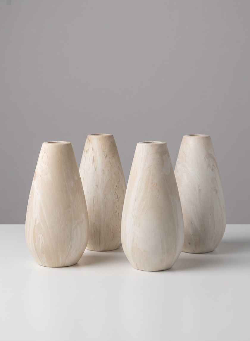 Four 5-inch tall "Travertine Look" ceramic bud vases, featuring a light beige teardrop shape and marble-like pattern, are arranged in two rows on a white surface against a plain gray background.