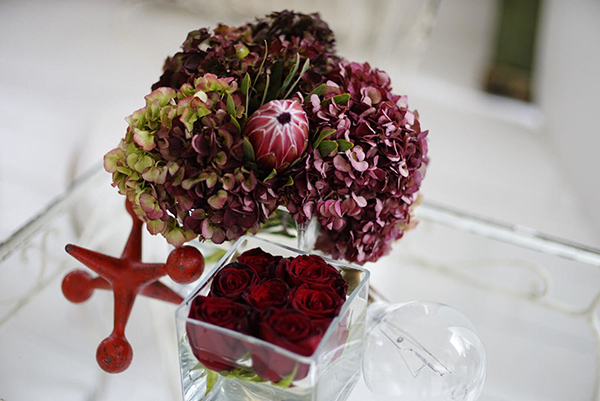 Antique hydrangea, South African King Protea, and red roses.