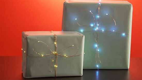 fairy lights wrapped around plain paper gifts
