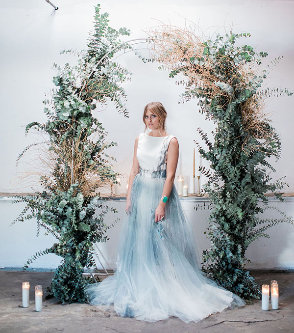 something blue wedding dress with eucalyptus arch