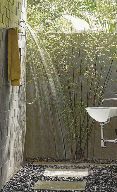 outdoor shower with stone pebble floor and bamboo plants