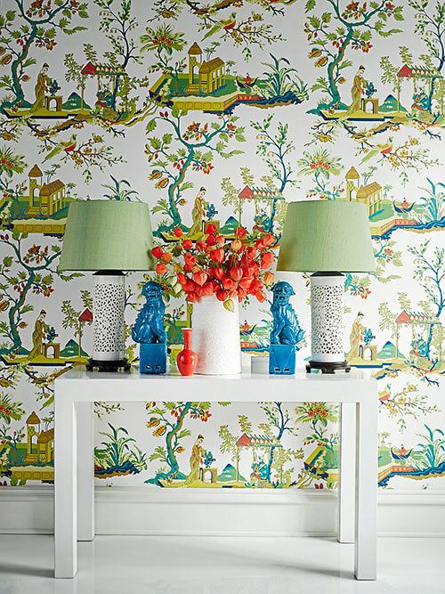 Scalamandre Ch'in Ling wallpaper behind a white table with lamps and ceramic vase with Chinese lanterns