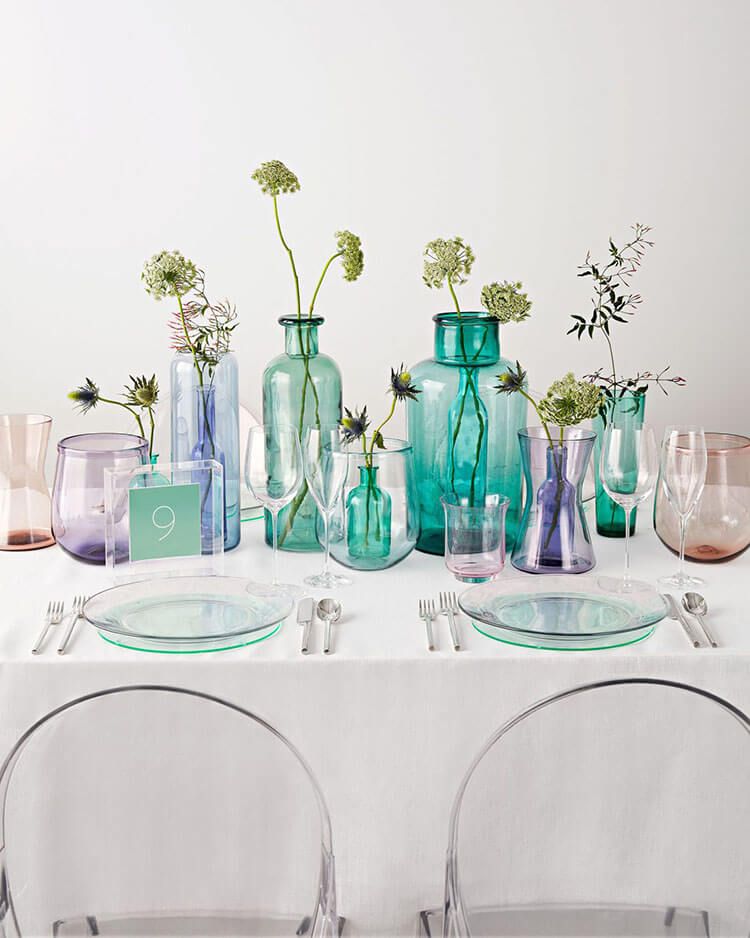 colored glass in blue aqua green and purple vases centerpiece with single stem flowers