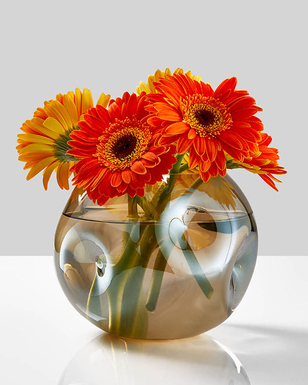dimpled luster amber glass fishbowl with orange gerberas
