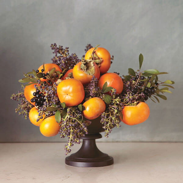 fruit centerpiece with kumquats and dark berries arrangement in black bowl