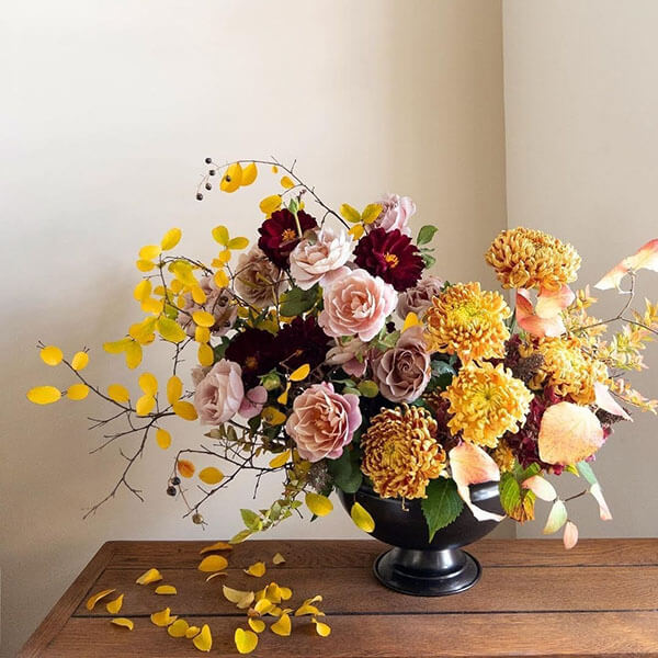 fall centerpiece with mums dahlias American grown roses in a dark copper metal bowl