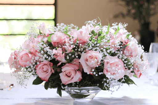 Elegant bouquet of pink roses and baby’s breath arranged on a table.