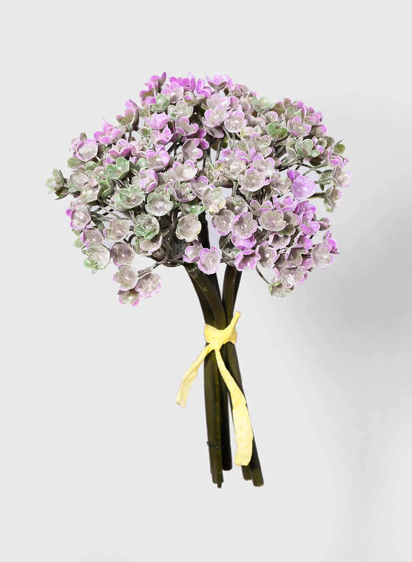 A bouquet of small purple and green flowers with frosted leaves, tied together with a yellow ribbon against a plain light gray background.