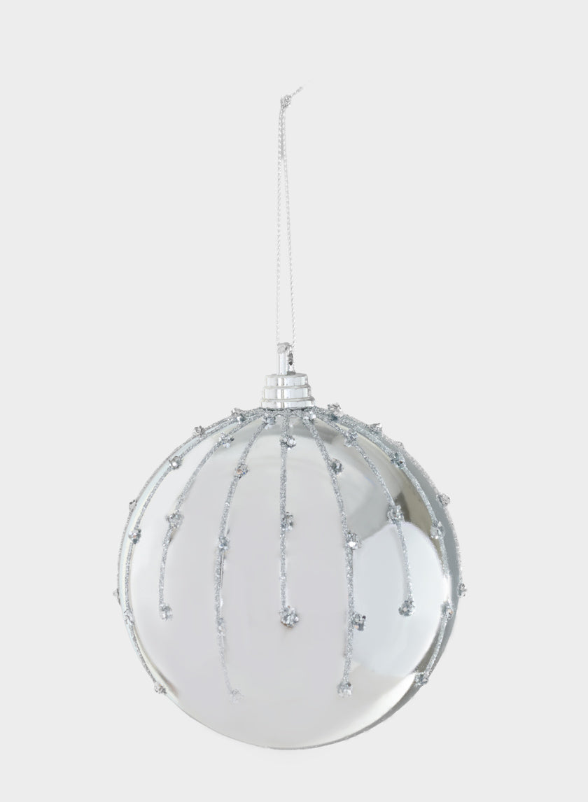 A 4in Silver Dust Lined Shiny Silver Plastic Ornament Ball, featuring glittery silver lines and dots, hangs from a thin silver string against a plain white background.