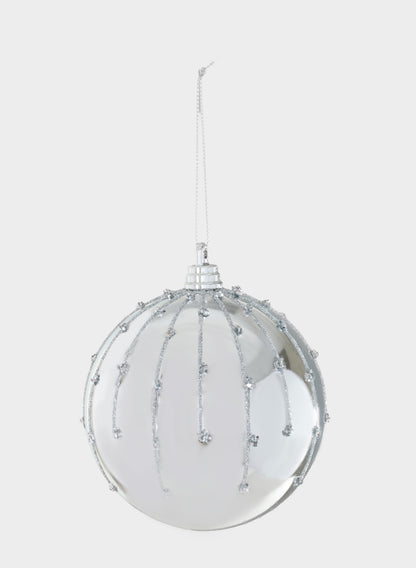 A 4in Silver Dust Lined Shiny Silver Plastic Ornament Ball, featuring glittery silver lines and dots, hangs from a thin silver string against a plain white background.