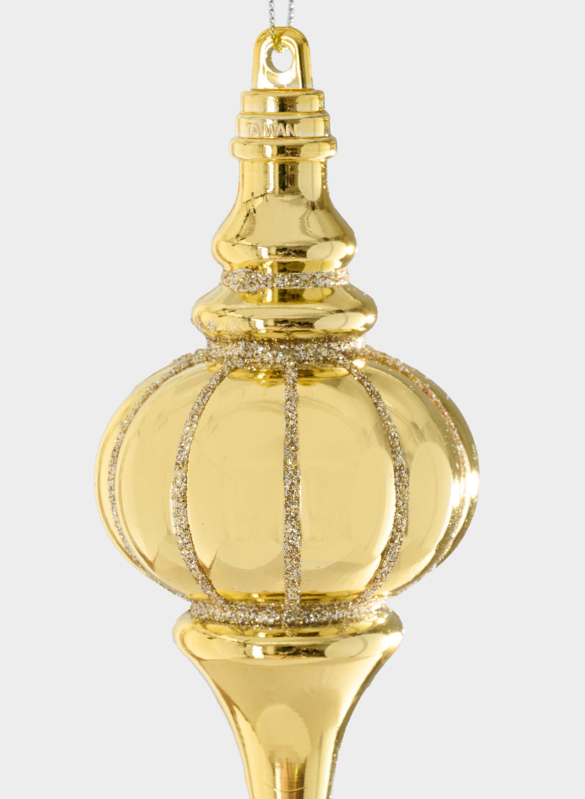A 5in Gold Glittred Plastic Finial ornament, featuring sparkling silver stripes, hangs by a string against a simple light background.