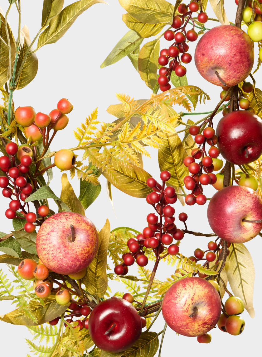 The 5ft Autumn Harvest Festive Garland with Apples features red apples and berries surrounded by green and yellow leaves, creating a colorful and vibrant pattern on a light background.