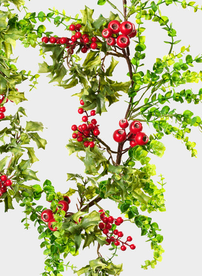 The 5ft Eucalyptus and Red Berry Garland features green leafy eucalyptus branches paired with clusters of bright red berries, arranged diagonally across a white background to create a vibrant, festive appearance.
