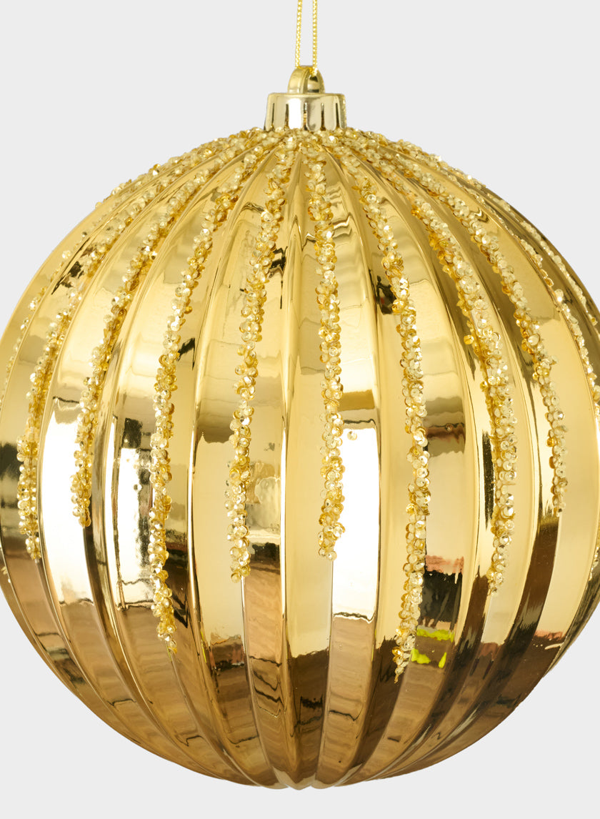 An 8in Plastic "Real Glass Look" Glitter Glazed Gold Ornament with vertical ridges and glittering beaded lines hangs from a yellow string against a plain light background.