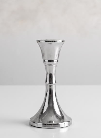 A single 4.5in tall silver metal candlestick stands upright on a white surface with a plain light background.
