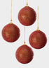 Four 4-inch round red ornament balls, fully adorned with rhinestones and beaded accents, each hanging from a thin gold string against a plain white background.