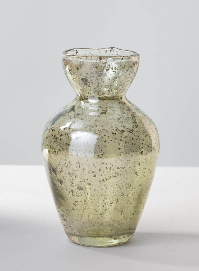The 6in Tall Jacques Green Vintage Bud Glass Vase features a rounded body, narrow neck, wide flared rim, and subtle green tint with small air bubbles in the glass, shown against a plain light background.