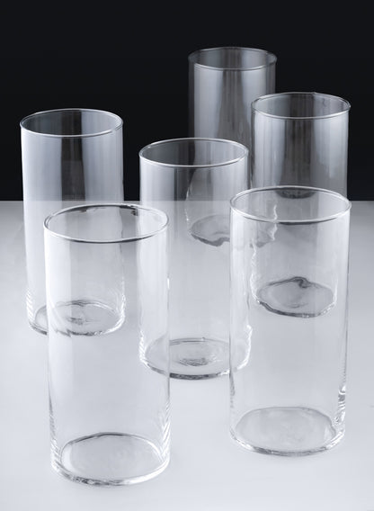 A set of six Best Value Glass Cylinder Vases is arranged in two rows on a light surface with a dark background. The vases are cylindrical, transparent, and display subtle reflections and shadows.