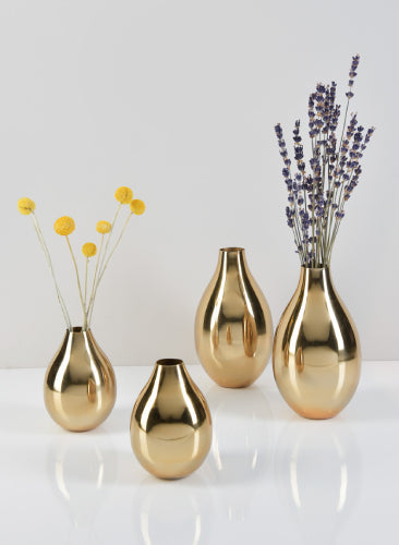 Set of gold vases with floral arrangements on a white background