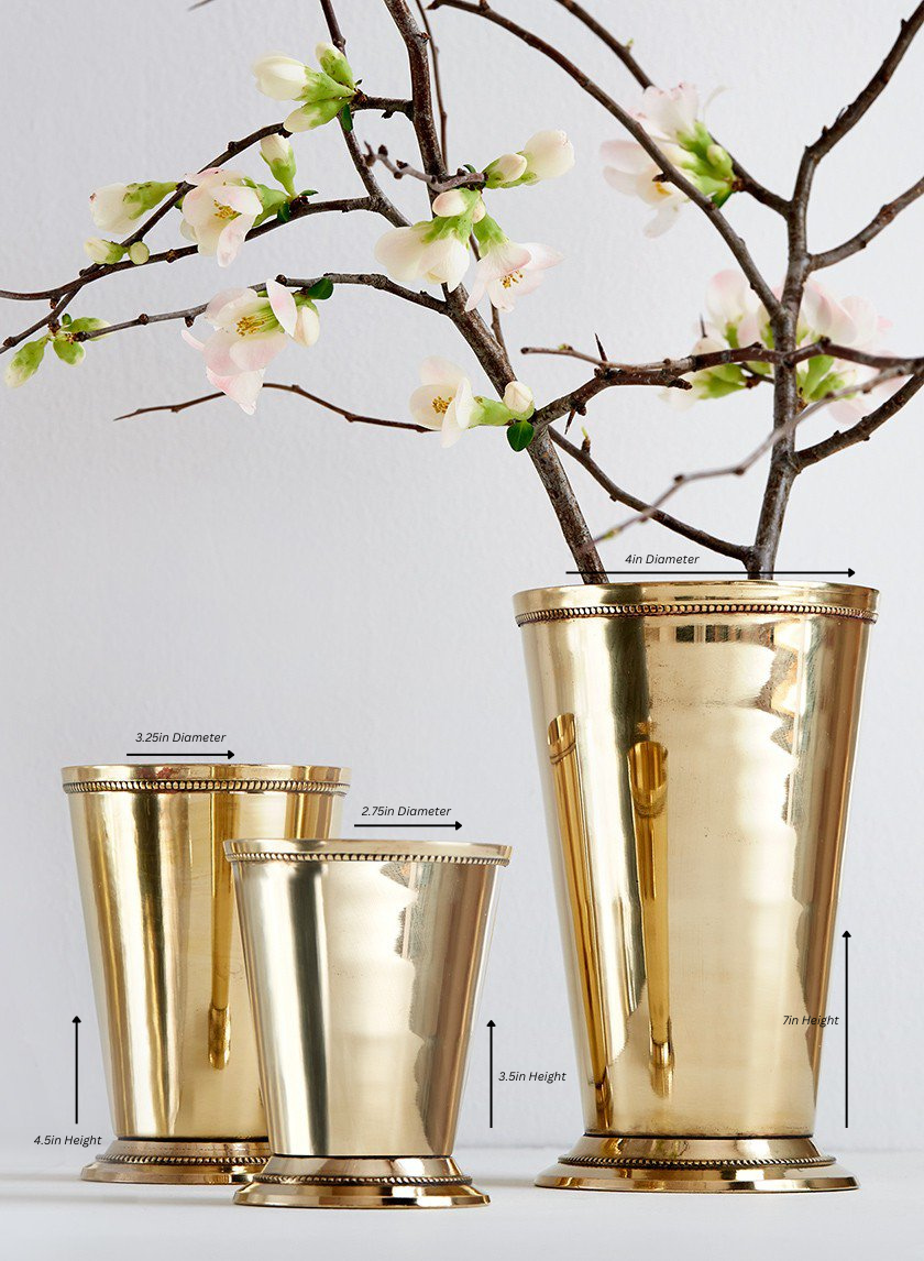 Three Polished Brass Julep Cups, sized 4.5", 5.5", and 7" tall with diameters of 3.25", 3.75", and 4", hold flowering branches—each cup lending elegant, reflective charm to your decor.