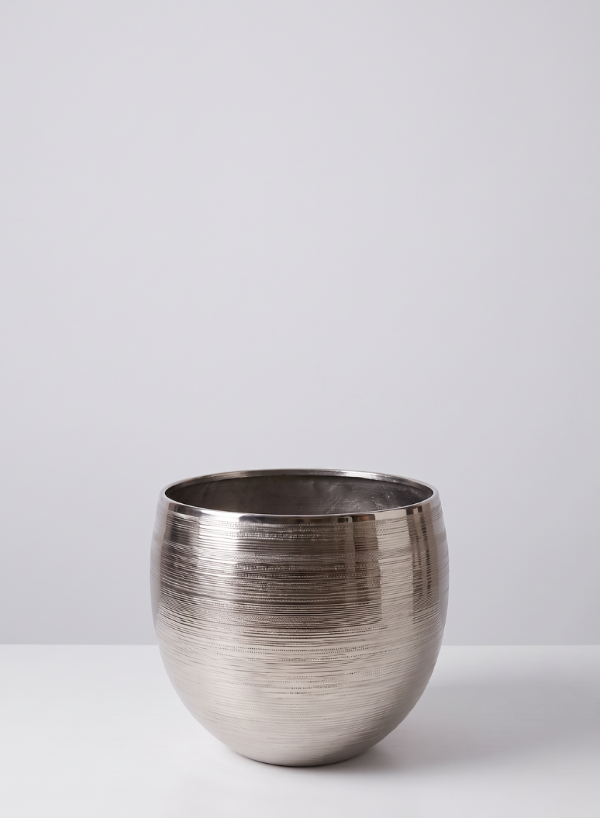 A 15.5in tall silver cache pot metal planter with a textured, horizontal ribbed pattern sits on a white surface against a light gray background.