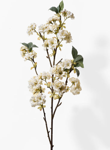 Artificial flower branch with white flowers and green leaves on a white background