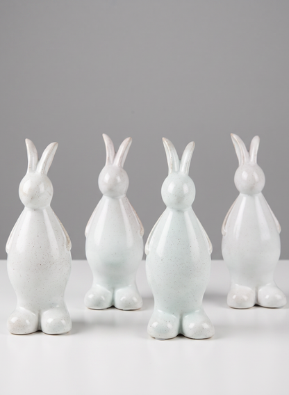 A set of four 7.5-inch aged white porcelain rabbits is arranged in two rows on a white surface against a plain gray background.