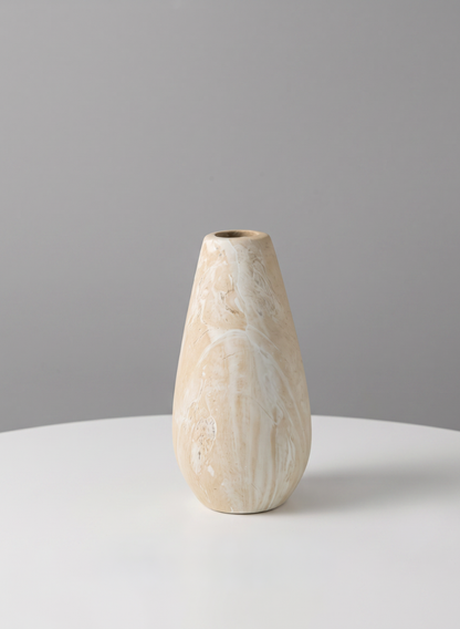 A 5in tall "Travertine Look" ceramic bud vase with a beige marbled finish and a narrow opening sits on a white round table against a plain gray background.