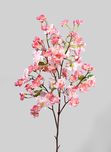 Artificial cherry blossom branch with pink flowers on a gray background