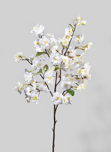 Artificial white flower branch on a gray background